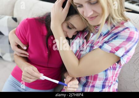 Amico felice per la sua amica che ha ottenuto test di gravidanza positivo, felice migliori amici ha ottenuto grandi notizie Foto Stock