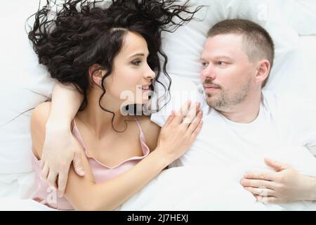 Una coppia deliziosa che si abbraccia a letto la mattina, una famiglia ben riposata che si gode stare a letto Foto Stock