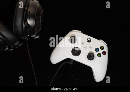 Controller di gioco Microsoft Xbox con cuffie su sfondo nero Foto Stock