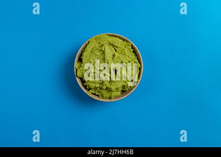 Vista dall'alto di una ciotola di ceramica piena di guacamole, la gustosa salsa fatta da avocado che proviene da cibo messicano. Concetto di cibo sano. Foto Stock