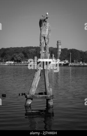 Un gabbiano su una statua di legno nel porto di Travemuende Foto Stock