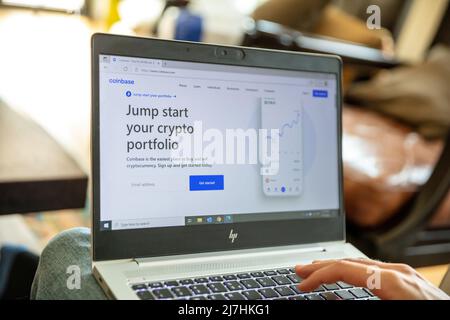 Grecia, Atene, gennaio 23 2022. Applicazione COINBASE CRYPTO Exchange. E commerce, cryptocurrency Secure buy, sell on laptop computer screen. Maschio mano su chiave Foto Stock