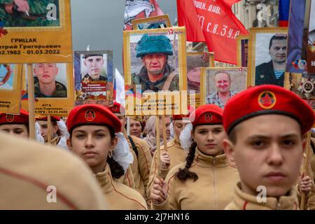 Mosca, Russia. 9th maggio 2022. I giovani hanno ritratti di persone che sono morte a Donbass nel 2014-2022, durante la marcia del reggimento immortale che segna il 77th° anniversario della vittoria nella seconda guerra mondiale in via Tverskaya nel centro di Mosca, Russia. Nikolay Vinokurov/Alamy Live News Foto Stock