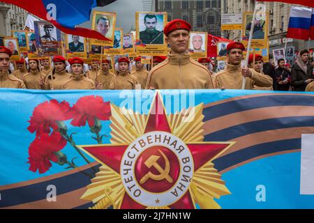 Mosca, Russia. 9th maggio 2022. I giovani hanno ritratti di persone che sono morte a Donbass nel 2014-2022, durante la marcia del reggimento immortale che segna il 77th° anniversario della vittoria nella seconda guerra mondiale in via Tverskaya nel centro di Mosca, Russia. Nikolay Vinokurov/Alamy Live News Foto Stock