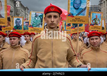 Mosca, Russia. 9th maggio 2022. I giovani hanno ritratti di persone che sono morte a Donbass nel 2014-2022, durante la marcia del reggimento immortale che segna il 77th° anniversario della vittoria nella seconda guerra mondiale in via Tverskaya nel centro di Mosca, Russia. Nikolay Vinokurov/Alamy Live News Foto Stock