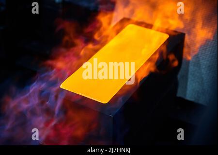 Il lingotto d'oro caldo si briviglia in forma di fusione nei gas di protezione Foto Stock