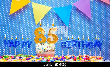 Buon compleanno candele lettere con un numero o cifra su uno sfondo blu bello. Spazio copia felice compleanno cartolina, candele accese Foto Stock