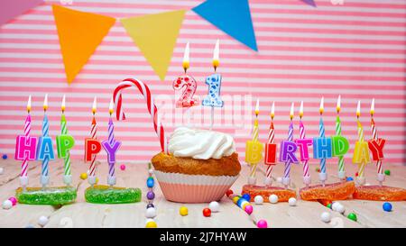 Buono compleanno felice su sfondo rosa, con una figura in un cupcake. Bello sfondo di compleanno felice con un numero con una candela che brucia. Festivo Foto Stock