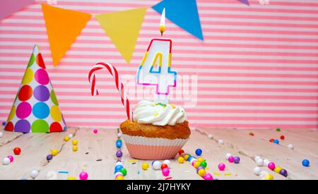 Buon compleanno su sfondo rosa. Bello sfondo di compleanno felice, con candele colorate brucianti in una canna da zucchero e una caramella. Festivo Foto Stock