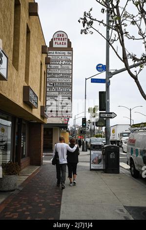 Foto di una coppia che cammina sulla seconda strada a Belmont Shore, il popolare quartiere dello shopping nel quartiere di lusso della spiaggia. Foto Stock