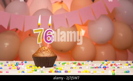 Decorazioni palloncino e una candela di compleanno felice con un numero in una torta. Auguri di buon compleanno in colori rosa per una ragazza, spazio copia. Muffin Foto Stock