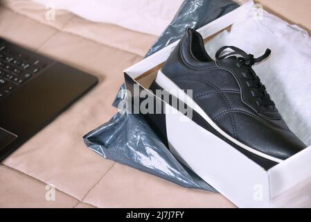 SHOPPING ONLINE. SCATOLA DI SNEAKERS NERE. Foto Stock