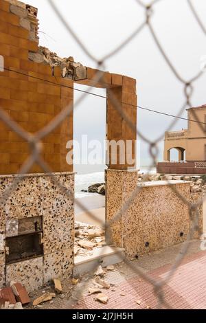 Casa dei pescatori distrutta da una tempesta sulle rive del Mar Mediterraneo in Andalusia, Spagna. Vista attraverso una recinzione. Foto Stock