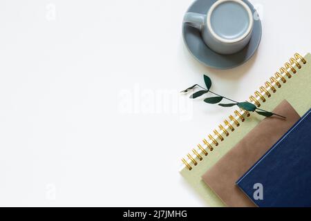 Notebook, tazza da caffè su sfondo bianco. Disposizione piatta, vista dall'alto, spazio per le copie Foto Stock