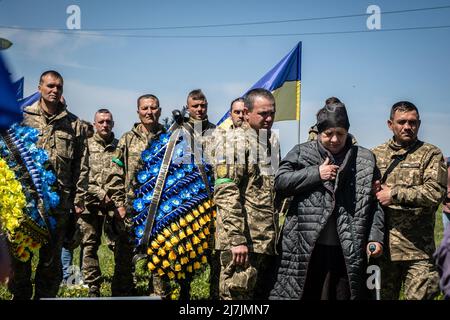 Dnipro, Ucraina. 07th maggio 2022. La madre e i soldati di Yakimenko si lamentano quando gli operai abbassano la bara nella tomba di un cimitero. Dopo l'invasione dell'Ucraina che ha segnato la più grande invasione militare in Europa dalla seconda guerra mondiale, la sanguinosa guerra ha lasciato i civili sfollati e numerosi civili e soldati uccisi, mentre le forze russe rafforzano il loro attacco all'est e al sud del paese durante la giornata della vittoria russa del maggio 9. Credit: SOPA Images Limited/Alamy Live News Foto Stock