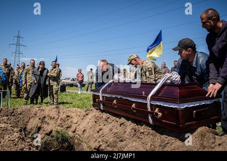 Dnipro, Ucraina. 07th maggio 2022. I lavoratori abbassano la bara di Yakimenko per la sepoltura in un cimitero di Dnipro. Dopo l'invasione dell'Ucraina che ha segnato la più grande invasione militare in Europa dalla seconda guerra mondiale, la sanguinosa guerra ha lasciato i civili sfollati e numerosi civili e soldati uccisi, mentre le forze russe rafforzano il loro attacco all'est e al sud del paese durante la giornata della vittoria russa del maggio 9. Credit: SOPA Images Limited/Alamy Live News Foto Stock