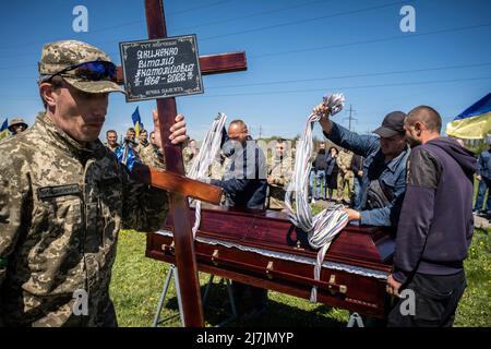 Dnipro, Ucraina. 07th maggio 2022. I lavoratori abbassano la bara di Yakimenko per la sepoltura in un cimitero di Dnipro. Dopo l'invasione dell'Ucraina che ha segnato la più grande invasione militare in Europa dalla seconda guerra mondiale, la sanguinosa guerra ha lasciato i civili sfollati e numerosi civili e soldati uccisi, mentre le forze russe rafforzano il loro attacco all'est e al sud del paese durante la giornata della vittoria russa del maggio 9. (Foto di Alex Chan Tsz Yuk/SOPA Images/Sipa USA) Credit: Sipa USA/Alamy Live News Foto Stock