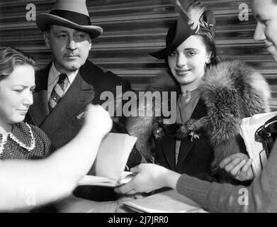 JOHN BARRYMORE con la moglie ELAINE BARRIE del 4th circondato da cacciatori di autografi alla stazione ferroviaria di Pasadena nel febbraio 1938 Foto Stock