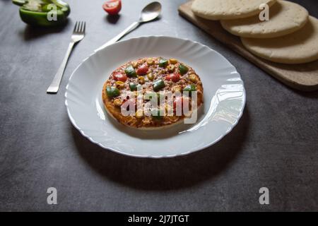 Popolare pizza italiana a base di snack in un piatto bianco su sfondo. Primo piano, messa a fuoco selettiva. Foto Stock
