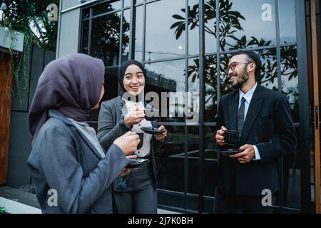 uomini d'affari asiatici che hanno conversazione durante la pausa di lavoro Foto Stock