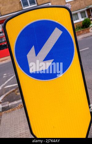 Epsom Surrey, Londra, 09 2022 maggio, Yellow Traffic Keep Left Island with Blue Circular Direction Arrow Foto Stock