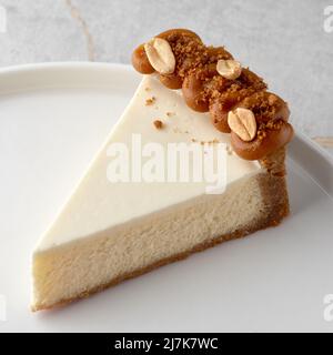 fetta di cheesecake al caramello su piastra bianca, fuoco selettivo, su piastra bianca. Primo piano, menu. Foto Stock