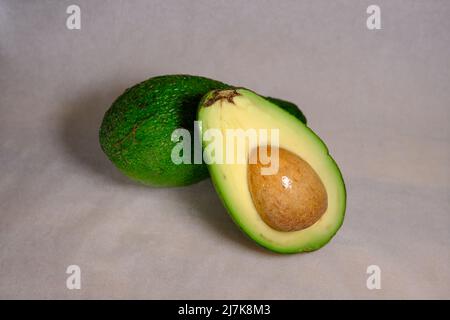 Panini all'avocado, metà dell'avocado, con arachidi e semi di zucca, anelli di cipolla, pepe rosso su sfondo bianco Foto Stock