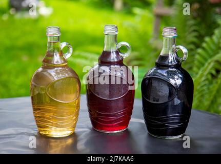 Tre bottiglie di diversi tipi di vino a tavola Foto Stock