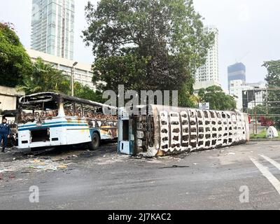 Colombo, Sri Lanka. 10th maggio 2022. Autobus e veicoli bruciati sono visti sulle strade e nel lago di Beira. Lo Sri Lanka ha visto il suo giorno più violento nelle ultime settimane quando il primo ministro Mahinda Rajapaksa ha rinunciato al suo posto. Gli scontri intorno al hanno causato almeno sette vittime e oltre 200 feriti. Le case e gli ufficiali dei membri del partito al governo e dei sostenitori sono stati bruciati durante gli scontri. Un coprifuoco a livello nazionale è stato chiamato fino a mercoledì, mentre l'esercito è stato dispiegato nella capitale Colombo. Foto Stock