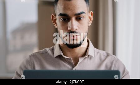 Serio maschio giovane ispanico uomo d'affari investitore agente freelancer digitando sul computer in ufficio a casa imprenditore mirato sviluppo nuovo progetto Foto Stock