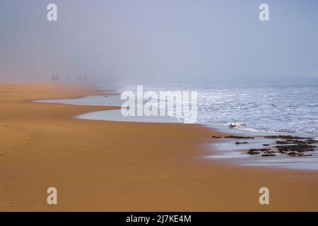 Camminando sulla spiaggia nella nebbia marina di Embleton Bay, Northumberland Coast, Inghilterra Foto Stock