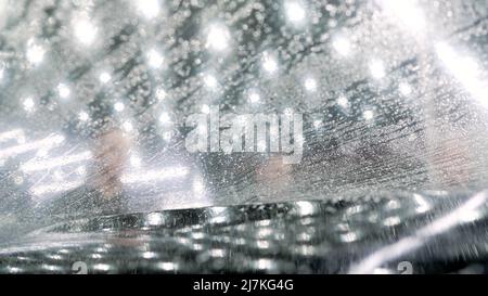 Dettagli auto. La pellicola protettiva è incollata sulla fuliggine della vettura. La pellicola protettiva è incollata alla fuliggine della vettura. Le mani dei lavoratori installano pai auto Foto Stock