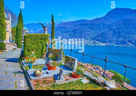 MORCOTE, SVIZZERA - 25 MARZO 2022: Il Cimitero Monumentale con tombe, arbusti di thuja, cipressi e il Lago di Lugano sullo sfondo, il 25 marzo a M. Foto Stock
