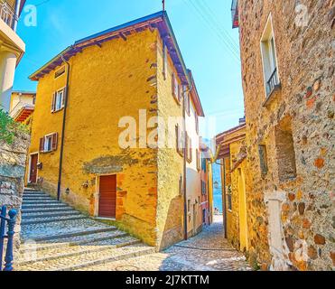 Goditi la passeggiata tra le case in pietra d'epoca della città vecchia di Morcote, con stradine curve strette, salite dolci e ripide, lucchetti e piccoli giardini, Switzer Foto Stock