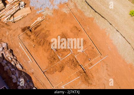 Nuova casa residenziale con posa tubi fognari e tubo dell'acqua nel terreno sotto la fondazione Foto Stock