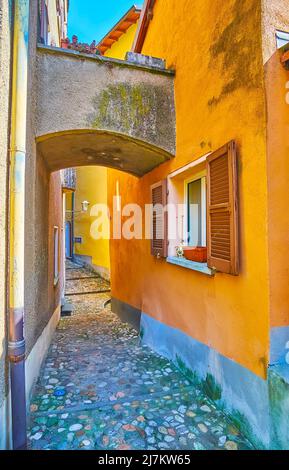 La stretta curva Strecia di Sardi strada con un antico arco tra le case, Morcote, Svizzera Foto Stock