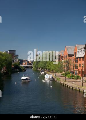 Il fiume Wensum nella città di Norwich, parte dei Norfolk Broads, con nuovo sviluppo e Cattedrale spire, Norwich, Norfolk, Inghilterra, Regno Unito Foto Stock