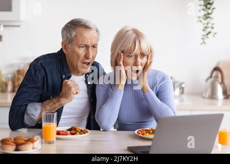 Coppia di anziani scioccati che guardano lo schermo del laptop Foto Stock