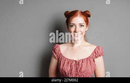 felice giovane donna con grande sorriso toothy e ciambelle spazio capelli rossi Foto Stock