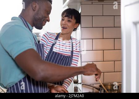 Felice coppia multirazziale giovane cucinare il cibo insieme a casa Foto Stock