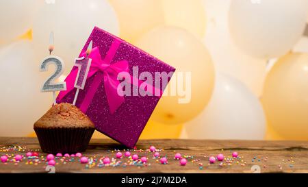 Buon compleanno con scatola regalo rosa per bambina. Bella tessera di compleanno con un cupcake e una candela che brucia Foto Stock