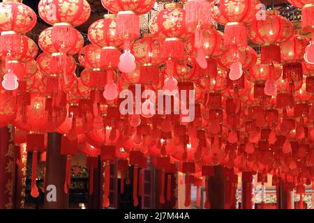 molte lanterne rosse cinesi sono state appese al tetto in un tempio Foto Stock