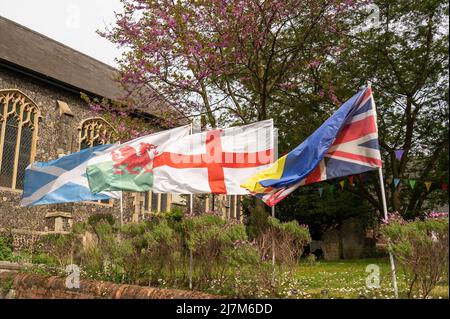 Le bandiere dell'Inghilterra, della Scozia, del Galles e dell'Unione Jack che ondeggiano nel vento ad una chiesa nella città di Norwich Foto Stock