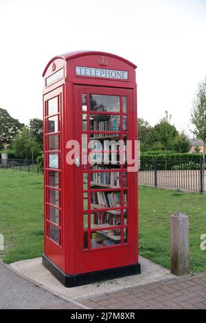 Un iconico telefono rosso britannico riproposto come biblioteca comunitaria, Fairfield, Bedfordshire, Regno Unito Foto Stock