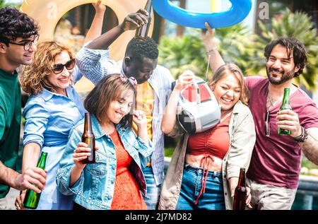 Gruppo di amici multiculturali che si divertono con barile e bottiglie di birra - gente di Gen z che si diverte con festa di primavera insieme - Foto Stock