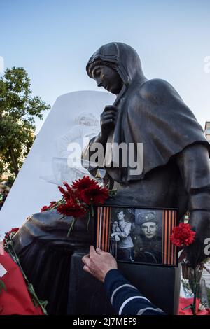 Atene, Grecia. 9th maggio 2022. Un uomo mette un ritratto del suo parente al monumento soldato sovietico durante un evento commemorativo del giorno della Vittoria. I russi residenti in Grecia hanno tenuto un evento in memoria della Giornata della Vittoria dell'esercito sovietico. (Credit Image: © Dimitris Aspiotis/Pacific Press via ZUMA Press Wire) Foto Stock
