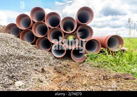 i tubi fognari si trovano in attesa di essere posati in una trincea in conformità con il progetto di infrastruttura sotterranea, fuoco selettivo Foto Stock