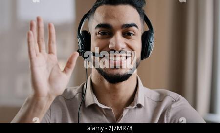 Sorridente operatore maschile ispanico businessman assistenza clienti assistente rappresentante saluto parlare alla webcam indossare cuffia con microfono Foto Stock