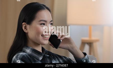 Sorridendo felice donna asiatica ritratto ragazza sorriso parlare telefono cellulare a casa. Primo piano signora coreana che parla smartphone flirting sul telefono cellulare Foto Stock