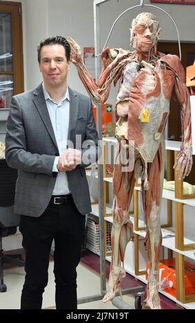 Guben, Germania. 12th Apr 2022. Rurik von Hagens, amministratore delegato, si trova nel Plastinarium accanto ad un plastinato a corpo pieno, destinato ad un'università americana. I 95 dipendenti hanno prodotto 600 plastinati per un valore di circa 6 milioni di euro nel 2021. il 95% è stato realizzato in base alle esigenze universitarie e il 5% per le mostre. Una nuova mostra avrà inizio a Dresda il 06 maggio. Credit: Bernd Settnik/dpa/Alamy Live News Foto Stock